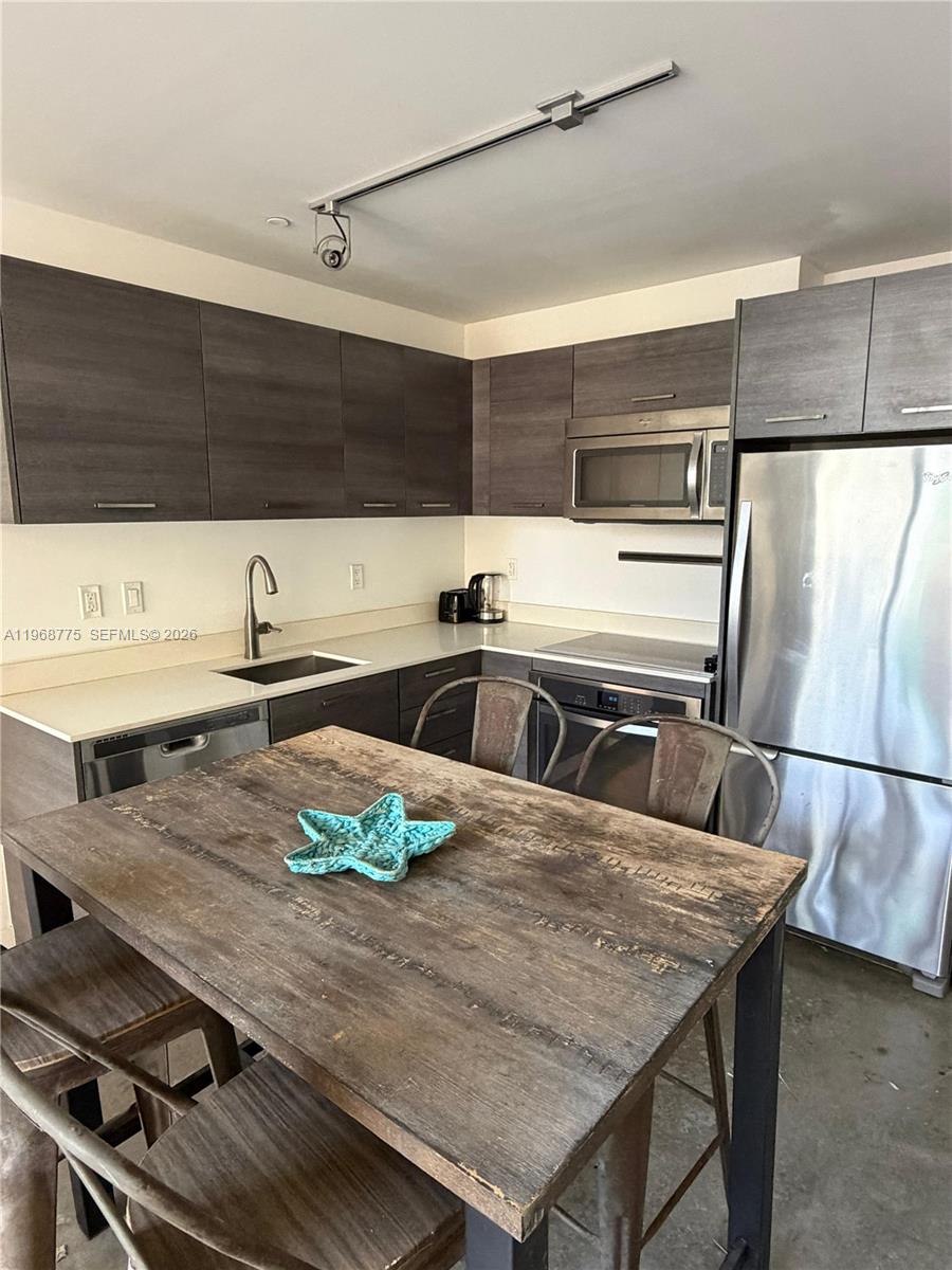 151 Southeast 1st Street, Unit 909 Miami, FL 33131 - Photo 5 of 29 a kitchen with a sink a stove and chairs