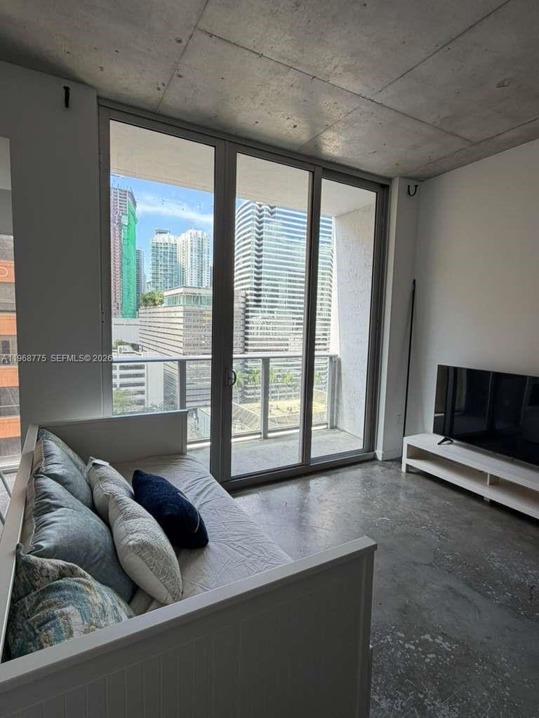 151 Southeast 1st Street, Unit 909 Miami, FL 33131 - Photo 6 of 29 a living room with furniture and a flat screen tv