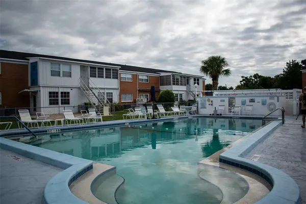 a house view with swimming pool and glass windows