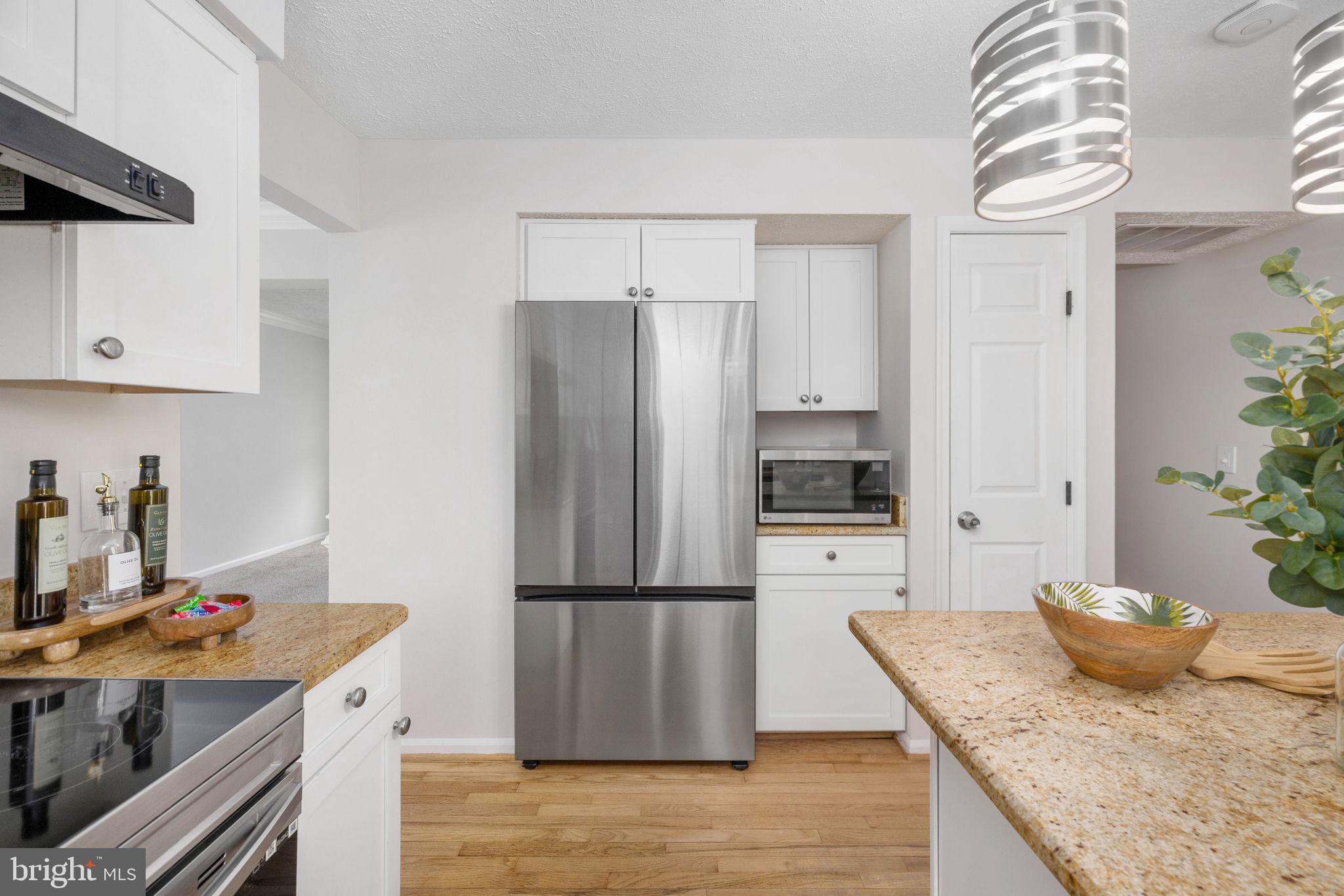 73 Spring Lake Drive Stafford, VA 22556 - Photo 19 of 71 a kitchen with granite countertop a refrigerator a stove and white cabinets