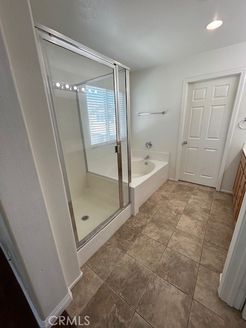 1911 Cefalu Court Riverside, CA 92507 - Photo 13 of 42 a bathroom with a glass shower door and a bathtub