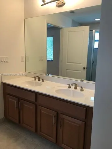 a bathroom with a double vanity sink and a mirror