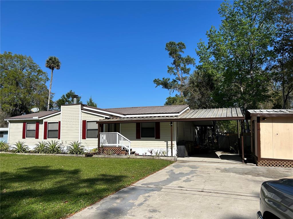 55624 Sam Street Astor, FL 32102 - Photo 3 of 12 a front view of a house with a garden
