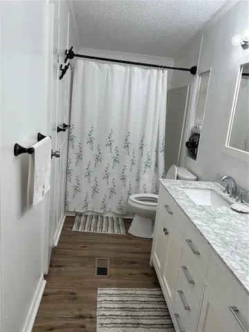 a bathroom with a granite countertop sink toilet and shower
