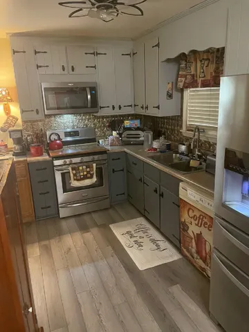 a kitchen with stainless steel appliances granite countertop a stove a sink and a microwave