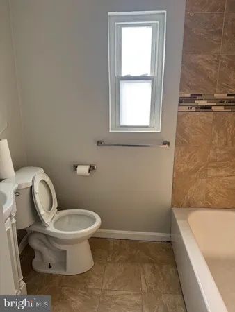 a bathroom with a toilet and a tub