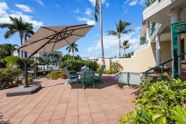 a view of a patio with couches and table and chairs under an umbrella