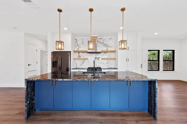 a view of kitchen with granite countertop stainless steel appliances and a wooden floor