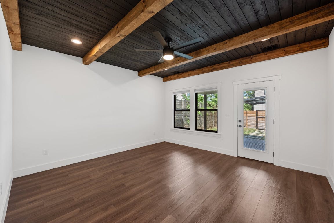 7008 Meador Avenue, Unit 1 Austin, TX 78752 - Photo 12 of 28 an empty room with wooden floor and windows