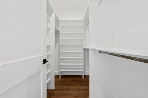 a view of walk in closet with empty racks