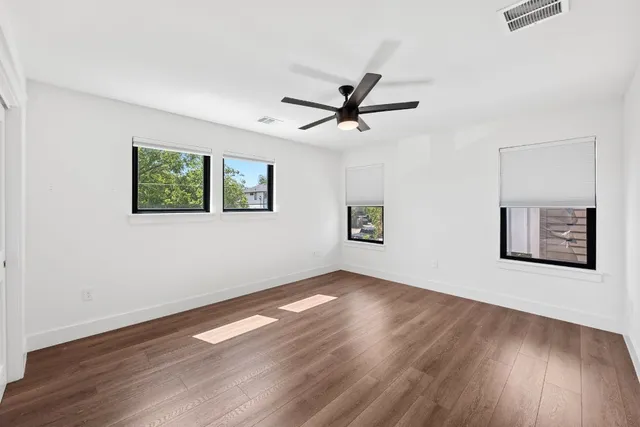 a view of a big room with wooden floor and windows