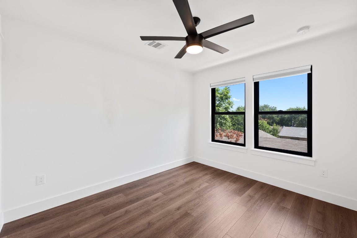 7008 Meador Avenue, Unit 1 Austin, TX 78752 - Photo 25 of 28 an empty room with wooden floor and windows