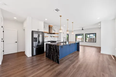 a kitchen with stainless steel appliances kitchen island wooden cabinets and wooden floor