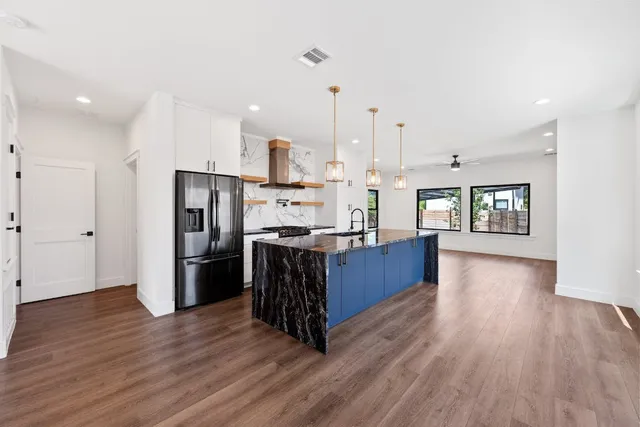 a kitchen with stainless steel appliances kitchen island wooden cabinets and wooden floor