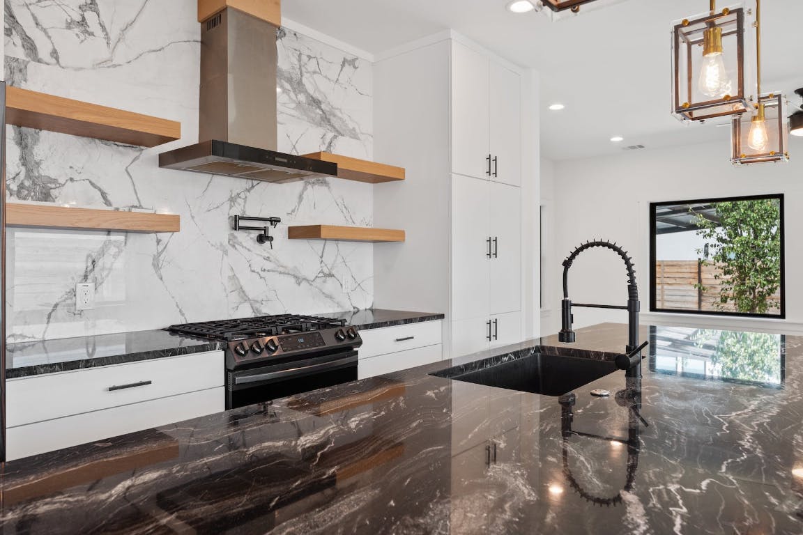 7008 Meador Avenue, Unit 1 Austin, TX 78752 - Photo 8 of 28 a kitchen with a stove and a white cabinets