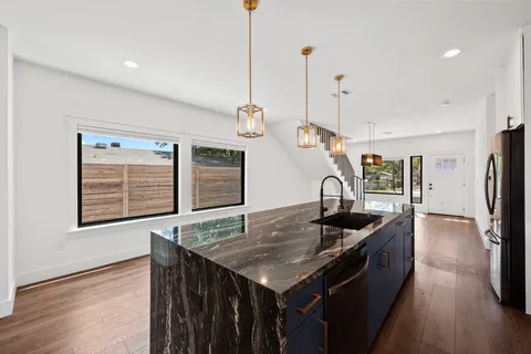 a kitchen that has a kitchen island a stove a counter space and a sink