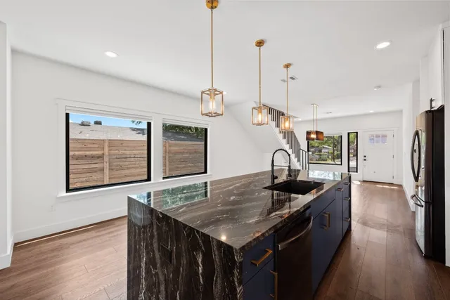a kitchen that has a kitchen island a stove a counter space and a sink