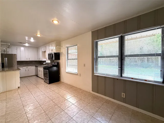 a large white kitchen with a large window