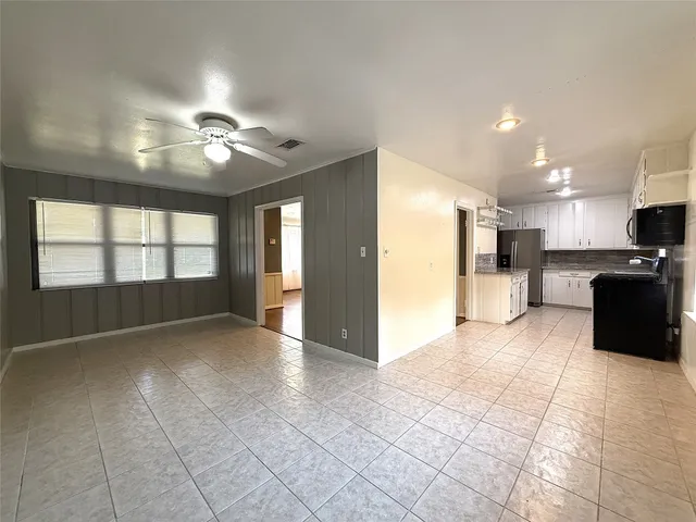 a view of an empty room with a kitchen