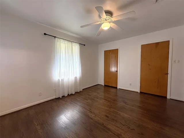 an empty room with wooden floor and window