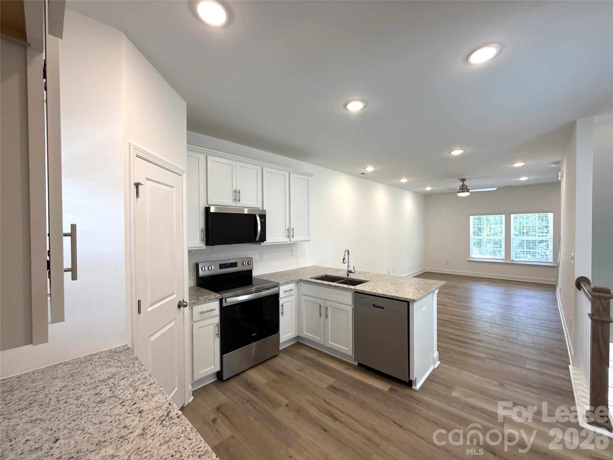 3220 Butler Hl Drive Matthews, NC 28105 - Photo 5 of 11 a kitchen with stainless steel appliances granite countertop a stove top oven a sink dishwasher a refrigerator and a oven with wooden floor