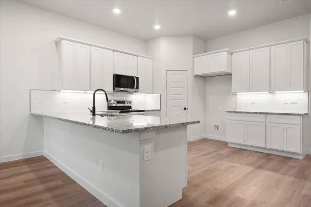 a kitchen with granite countertop cabinets and stainless steel appliances