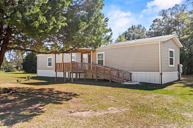 a view of a house with backyard and trees