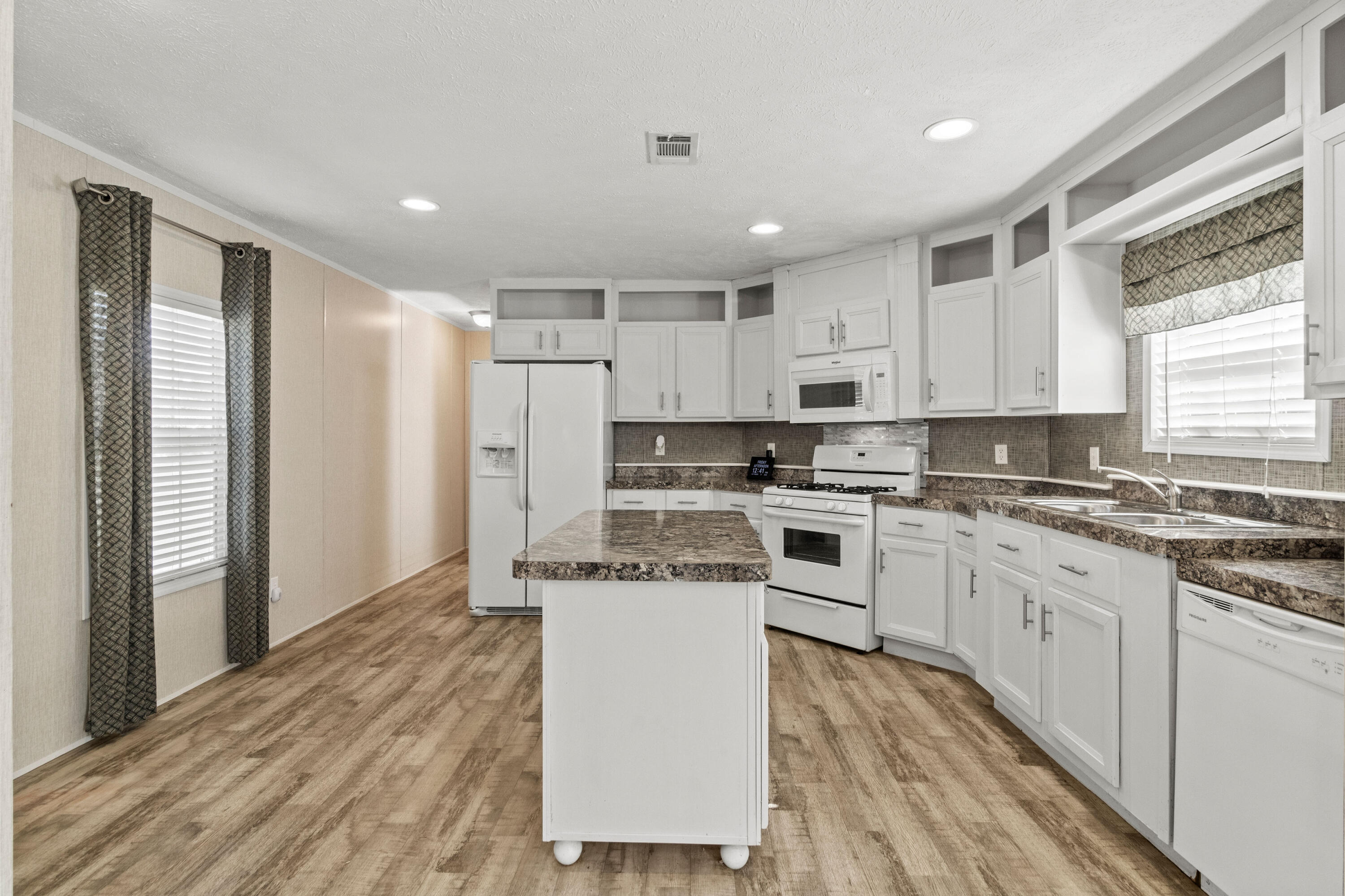 7419 Pappa Lawrence Road Laurel Hill, FL 32567 - Photo 13 of 40 a kitchen with stainless steel appliances granite countertop a stove a sink and white cabinets with wooden floor