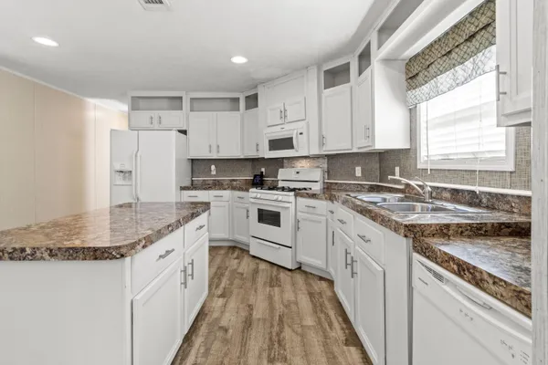a kitchen with granite countertop cabinets stainless steel appliances and a window