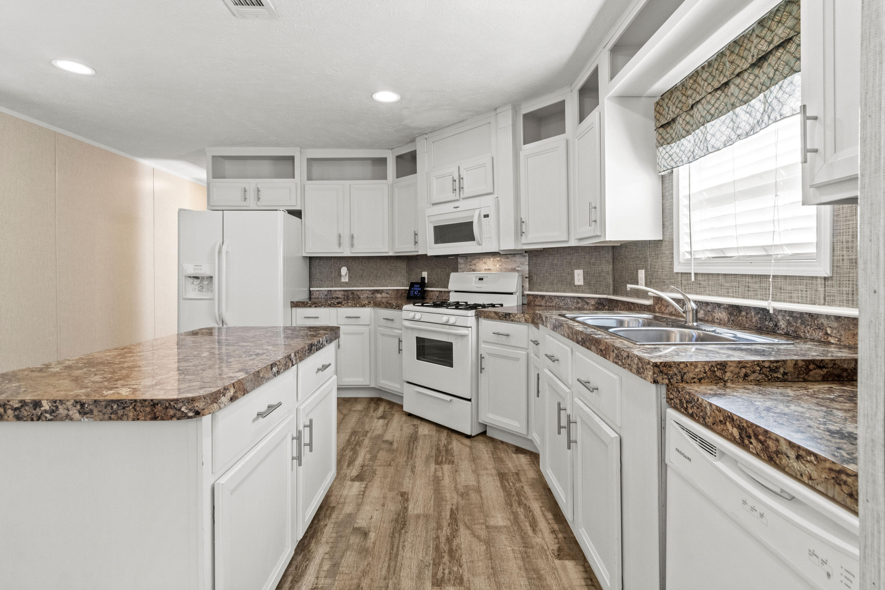 7419 Pappa Lawrence Road Laurel Hill, FL 32567 - Photo 16 of 40 a kitchen with granite countertop a sink stainless steel appliances white cabinets and a window
