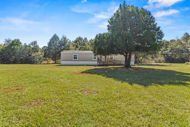 a view of a house with a yard and sitting area