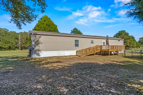 a view of a house with backyard and trees