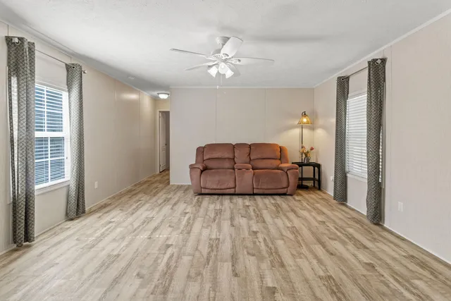 a living room with furniture and a ceiling fan