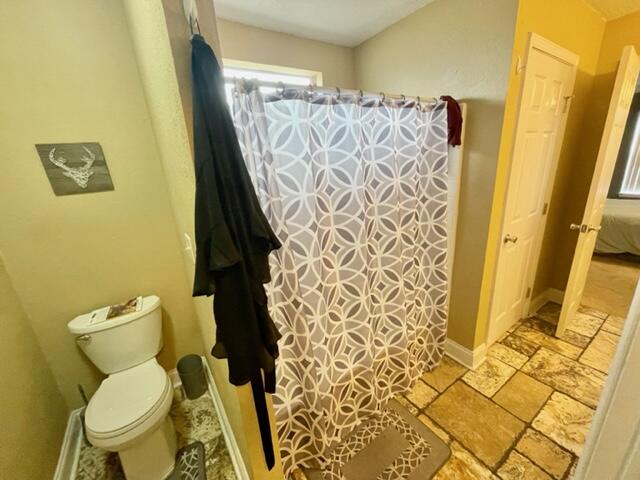 229 Limestone Circle Crestview, FL 32539 - Photo 11 of 22 a white toilet sitting next to a sink and a shower curtain