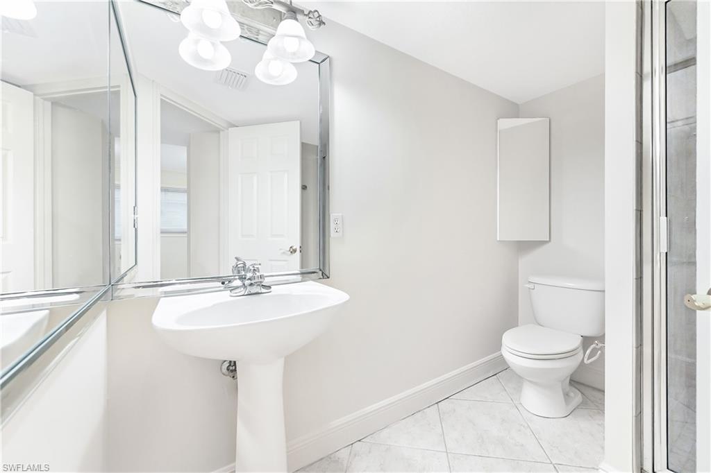 950 7th Avenue South, Unit 26 Naples, FL 34102 - Photo 11 of 15 a bathroom with a sink a toilet and mirror