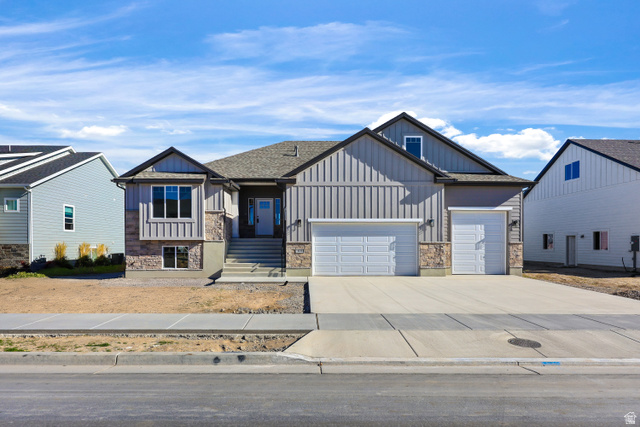 1139 South 4475 West West Point, UT 84015 - Photo 1 of 33 View of front facade with board and batten siding, stone siding, concrete driveway, and an attached garage