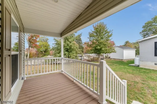 a view of a deck with wooden floor and fence next to a yard