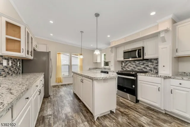 a large kitchen with stainless steel appliances granite countertop a stove sink and cabinets