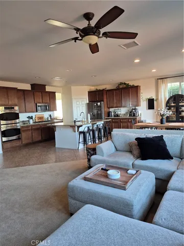 a living room with stainless steel appliances kitchen island granite countertop a couch and a view of kitchen
