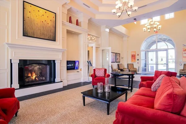 a living room with furniture a fireplace and a chandelier
