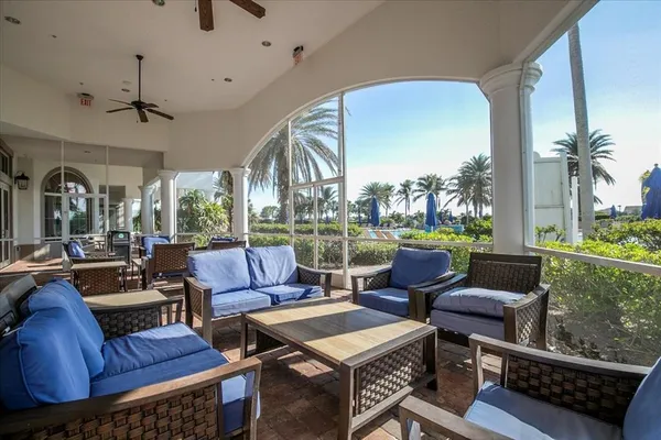 a living room with patio furniture and a floor to ceiling window