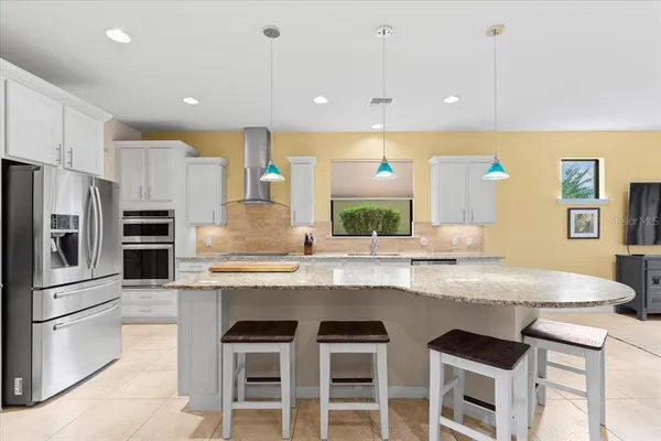 a kitchen with stainless steel appliances granite countertop a sink and a refrigerator