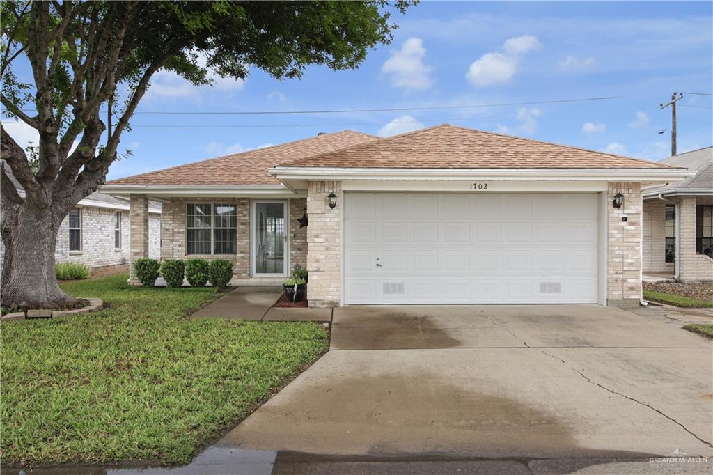 1702 Aries Street Mission, TX 78572 - Photo 1 of 19 a front view of a house with a yard and garage