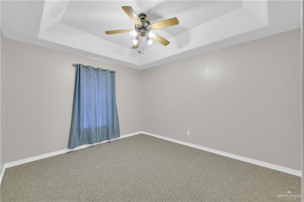 1702 Aries Street Mission, TX 78572 - Photo 13 of 19 an empty room with a ceiling fan and a window