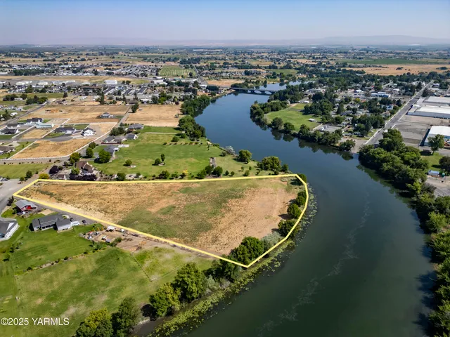an aerial view of a house with a yard and lake view