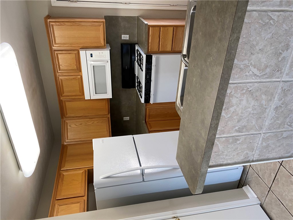 2429 Pintail Loop College Station, TX 77845 - Photo 3 of 20 a kitchen with a refrigerator a stove top oven cabinets and a sink
