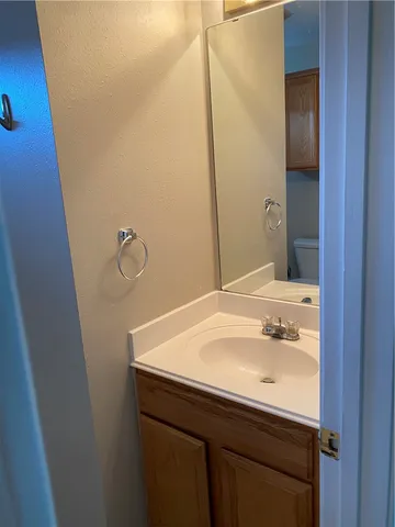 an empty room with a chandelier fan and windows