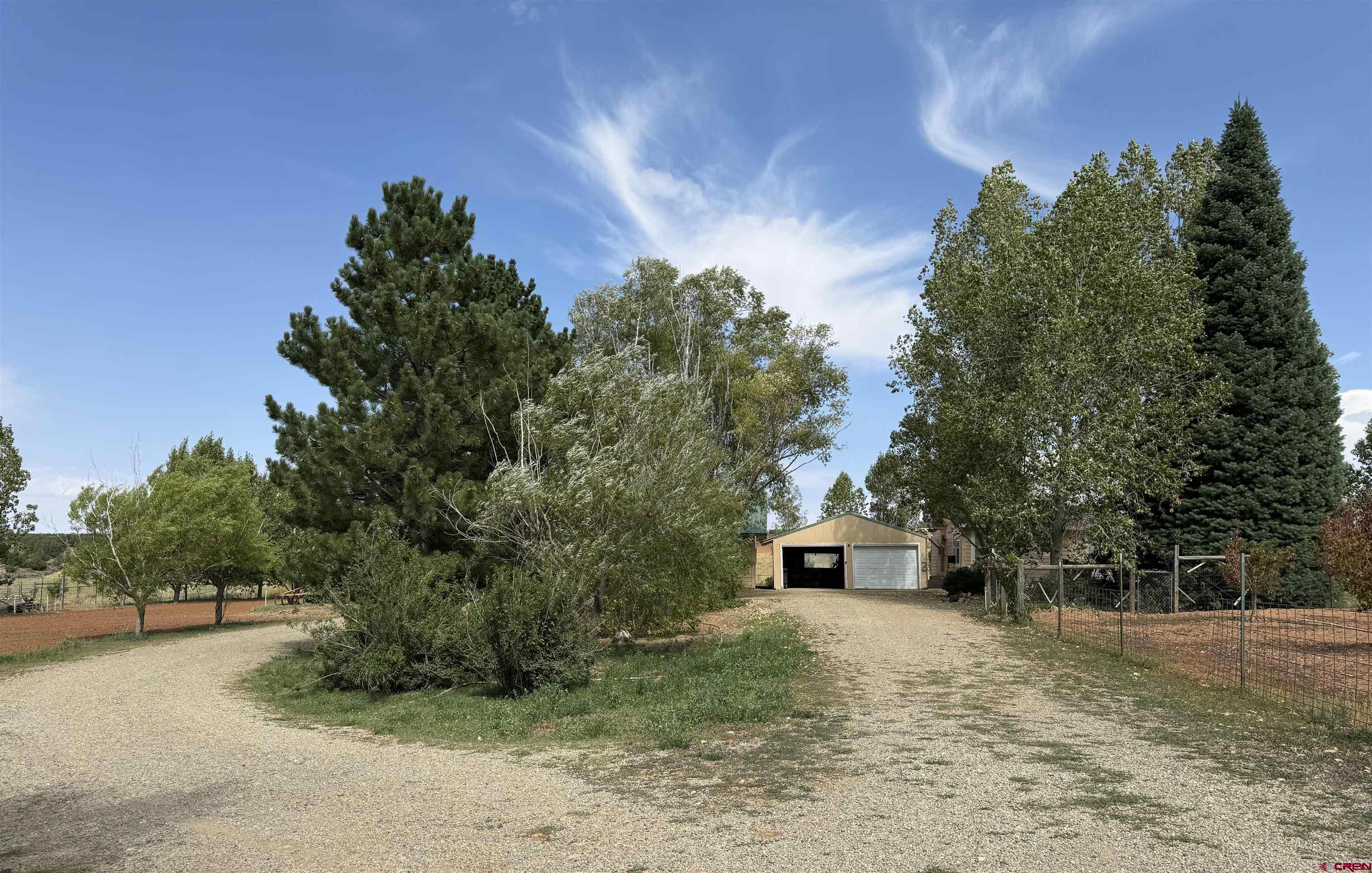12383 Rd M Cahone, CO 81320 - Photo 34 of 42 a front view of a house with a yard and a garage