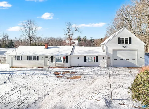 a view of a white house with a yard covered in snow