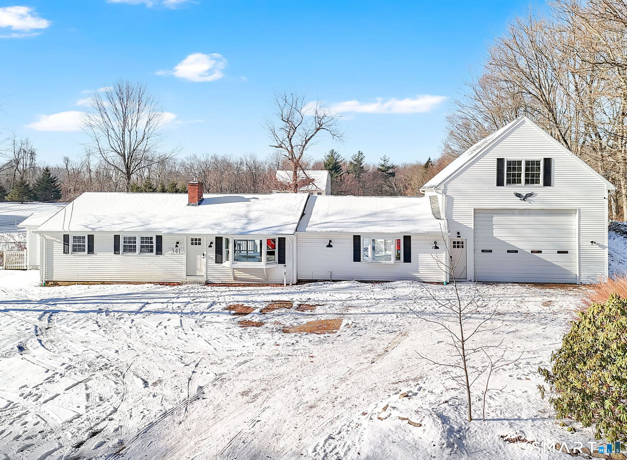 a view of a white house with a yard covered in snow